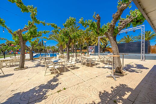 Terraza de animación exterior, mesas, sillas, piscina en el camping CAPFUN Mirmanda en Cambrils.