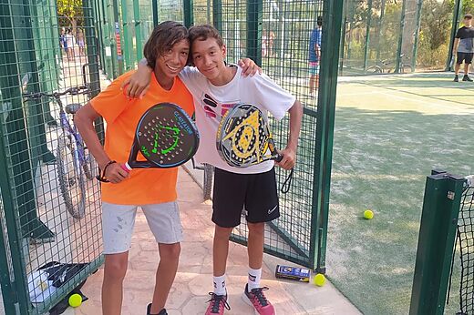 Jóvenes jugadores de pádel sonrientes en la pista del camping CAPFUN Mirmanda en Cambrils.