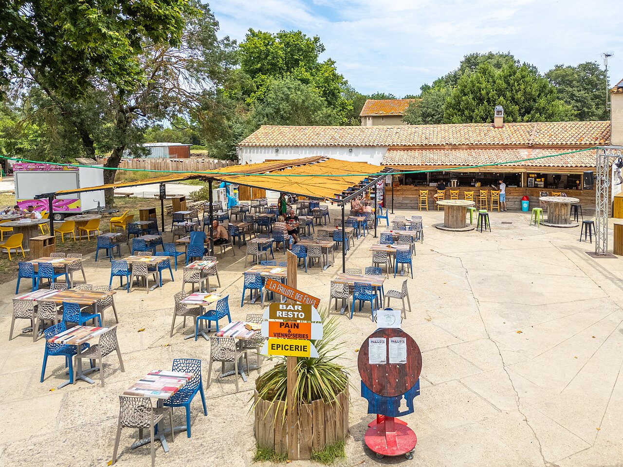 Terraza exterior del restaurante, bar y tienda en camping VAGUES OCEANES Monte Cristo en Vauvert (30).