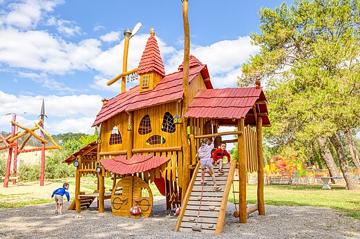 Parque infantil de madera con niños en el camping VAGUES OCEANES Monte Cristo en Vauvert (30).