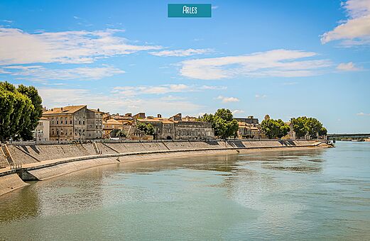Orillas del Ródano y edificios históricos en Arles, ciudad para visitar en Provenza.