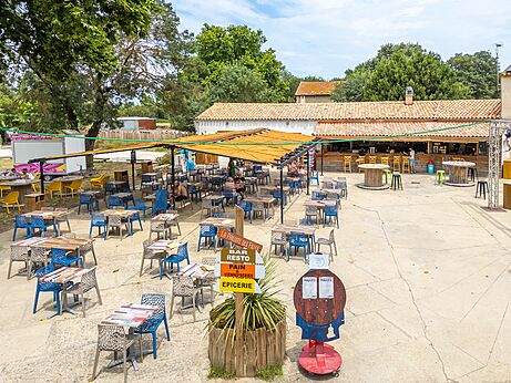 Terraza exterior del restaurante, bar y tienda en camping VAGUES OCEANES Monte Cristo en Vauvert (30).