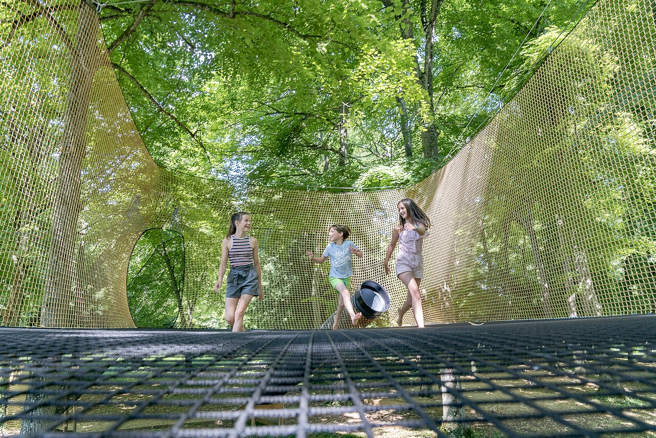 Ni�os juegan en redes suspendidas entre �rboles, camping CAPFUN Montsabert.