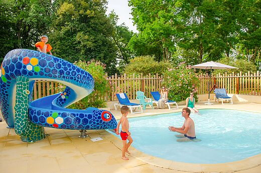 Piscina exterior con tobogán serpiente y niños en el camping CAPFUN Montsabert en COUTURES (49).