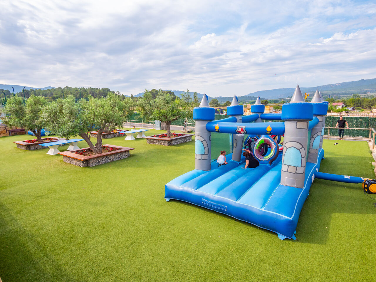 Castillo hinchable azul para ni�os en c�sped verde en el camping CAPFUN Montblanc Park en Montblanc (43).