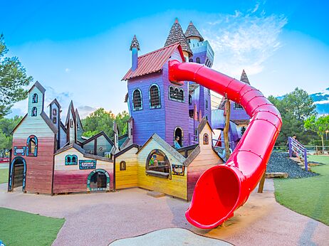 Parque infantil castillo colorido con tobogán rojo en el camping CAPFUN Montblanc Park en Montblanc (43).