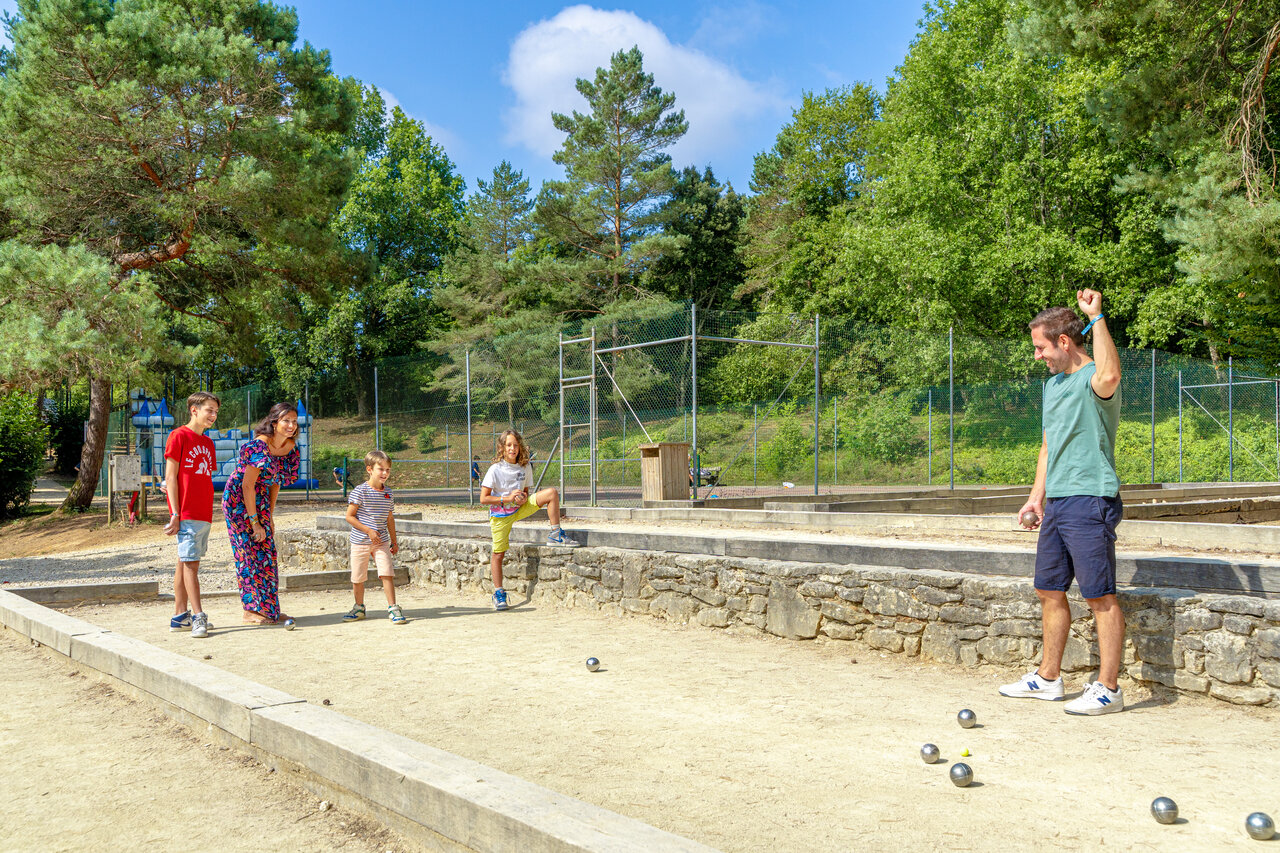 Familia jugando a la petanca en la cancha del camping CAPFUN Moulinal en BIRON (24).