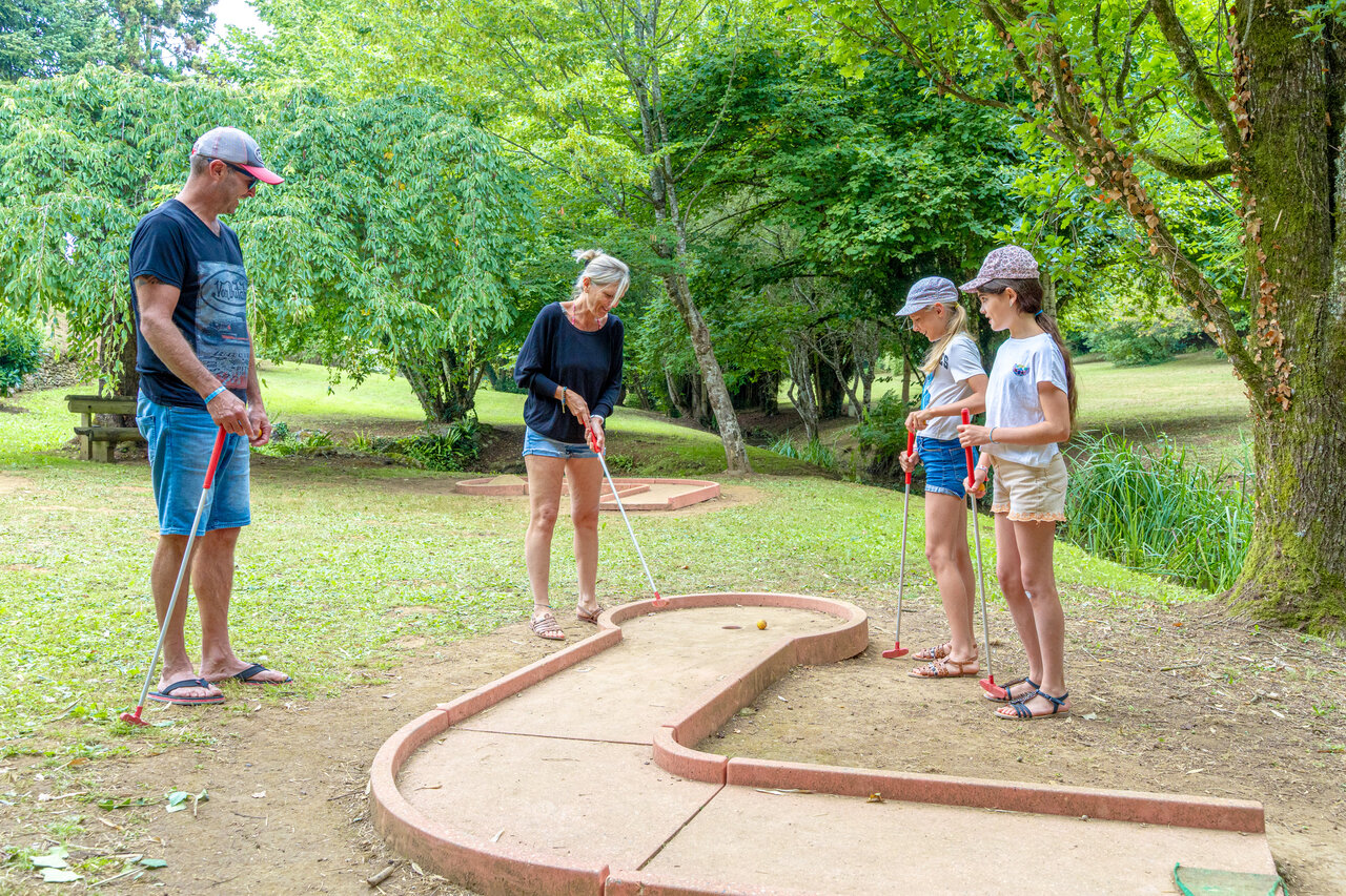 Familia disfrutando del minigolf en la naturaleza en el camping CAPFUN Moulinal en BIRON (24).
