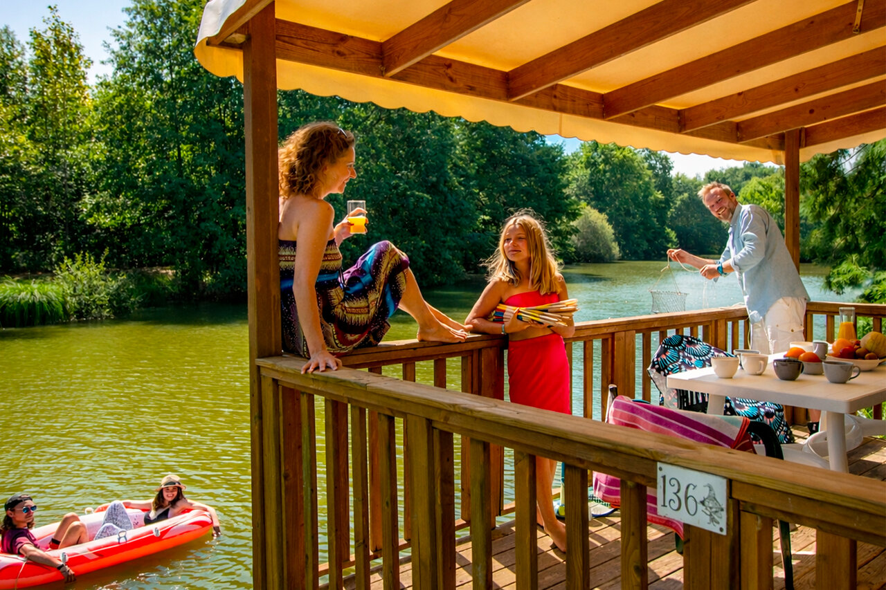 Familia terraza Mobil-home lago en el camping CAPFUN Moulinal en BIRON (24).
