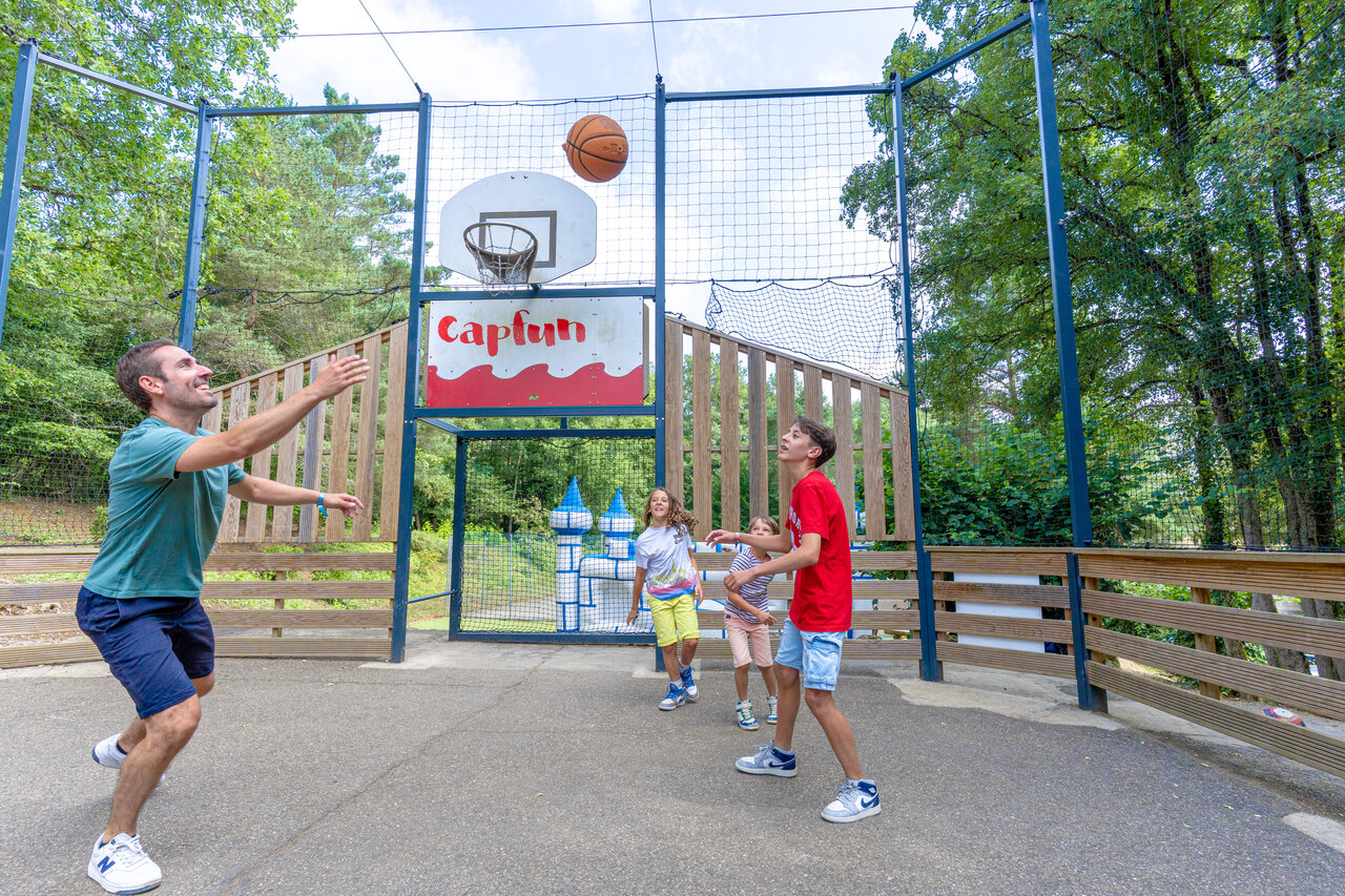 Cancha de baloncesto con familia jugando en el camping CAPFUN Moulinal en BIRON (24).