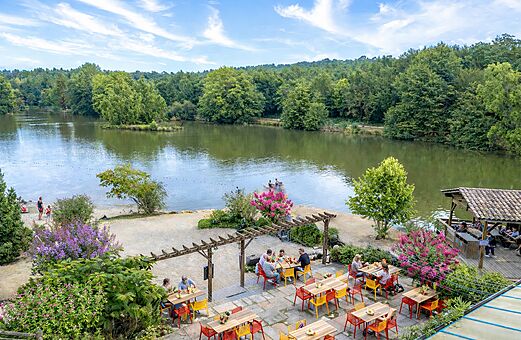 Restaurante exterior con terraza y vista al lago en el camping CAPFUN Moulinal en BIRON (24).