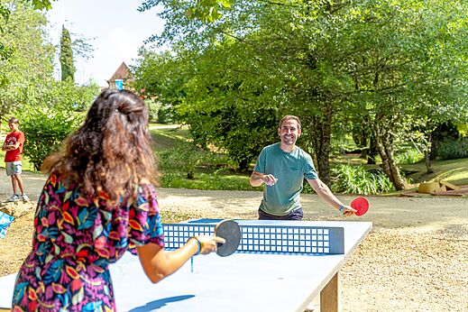 Partido de tenis de mesa entre adultos en el camping CAPFUN Moulinal en BIRON (24).