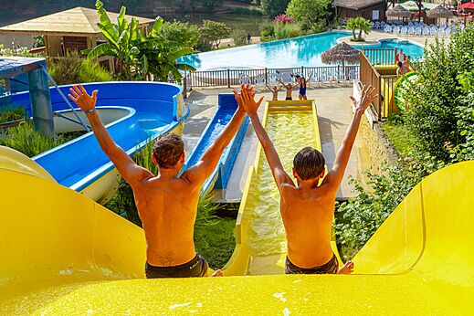Dos personas en toboganes y piscina en el camping CAPFUN Moulinal en BIRON (24).