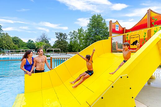 Tobogán acuático amarillo y piscina exterior en el camping CAPFUN Moulinal en BIRON (24).