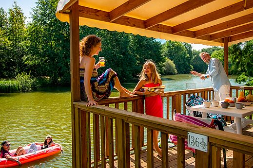 Familia en terraza de Mobil-home, lago y actividades n�uticas CAPFUN Moulinal en BIRON (24).