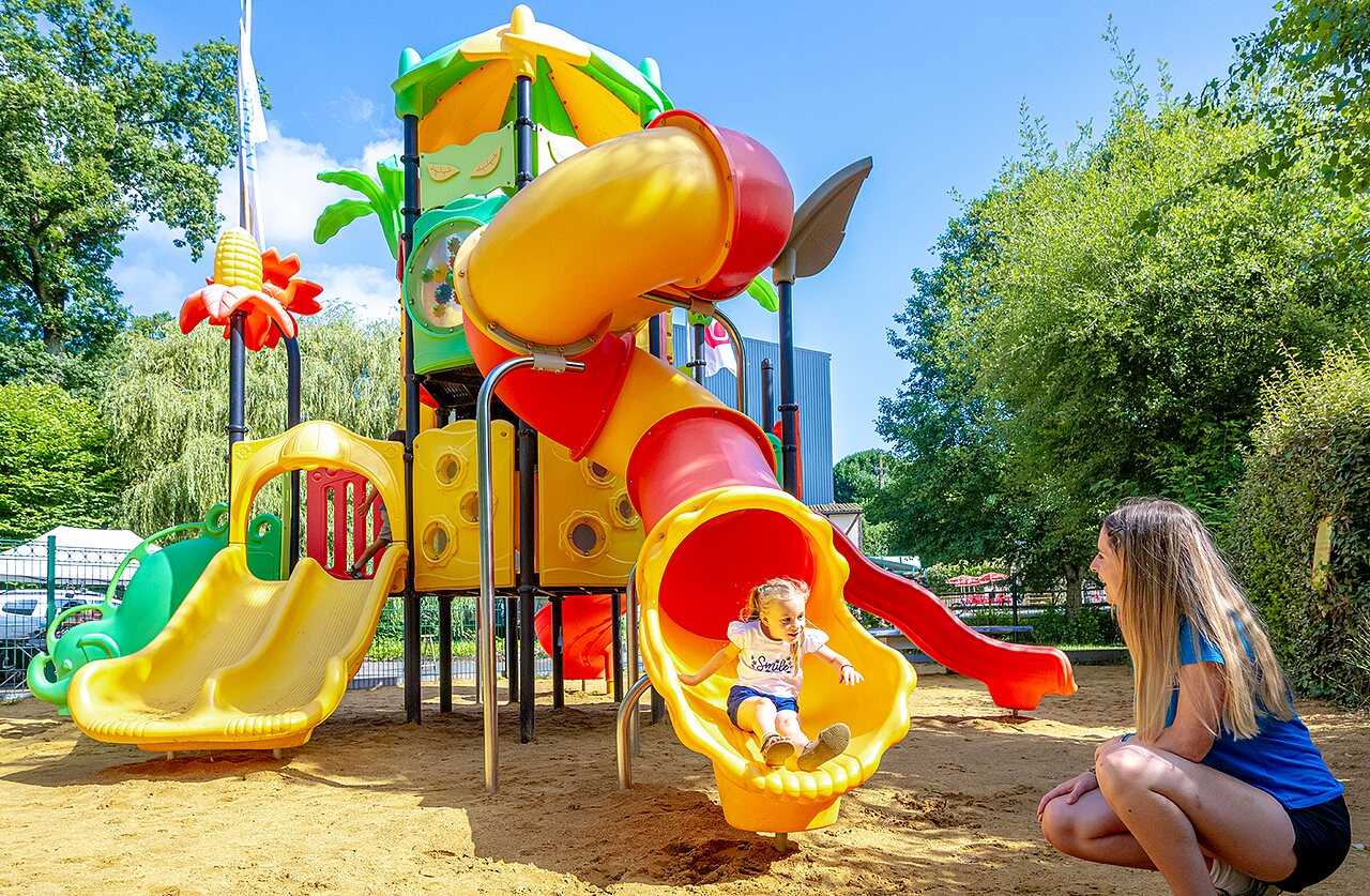 Parque infantil colorido con toboganes y ni�o en el camping VAGUES OCEANES Moulin de Cadillac en Noyal-Muzillac (56).