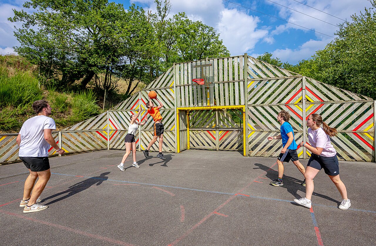 Cancha multideportiva con j�venes jugando baloncesto en el camping VAGUES OCEANES Moulin de Cadillac en Noyal-Muzillac (56).