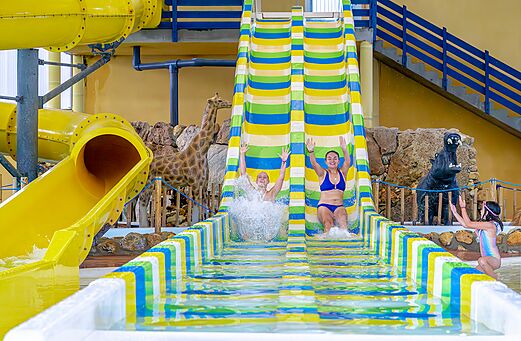 Toboganes acuáticos coloridos y bañistas en el camping VAGUES OCEANES Moulin de Cadillac (56).