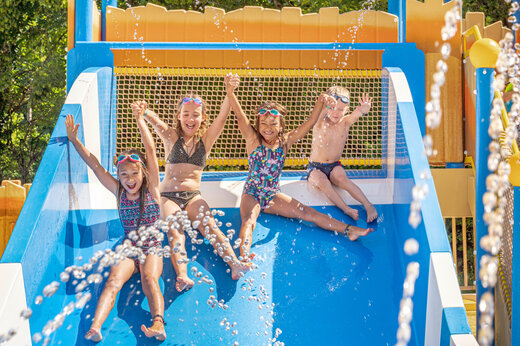Ni�os sonrientes en tobog�n acu�tico en el camping CLICOCHIC Moulin du Roch en Saint Andre D'Allas.