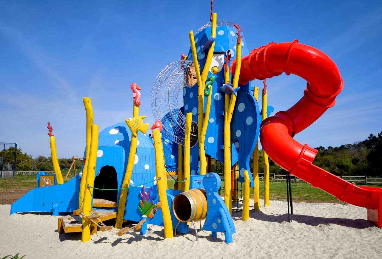 Zona de juegos marina, tobog�n rojo, estructuras azules en camping VAGUES OCEANES Moustoir.