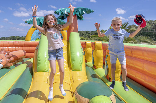 Niños saltando en una estructura hinchable gigante en el camping VAGUES OCEANES Moustoir en Carnac (56).