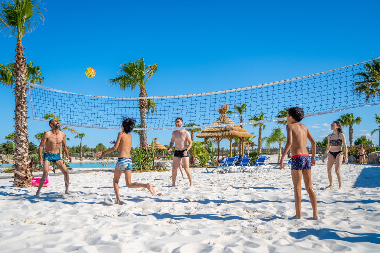 Familia jugando voleibol de playa en la arena fina del camping CAPFUN La Nautique en Narbonne (11).