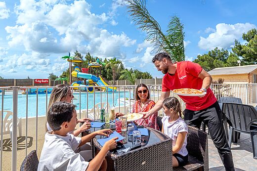 Restaurante exterior con familia, piscina, en el camping CAPFUN La Nautique en Narbonne.
