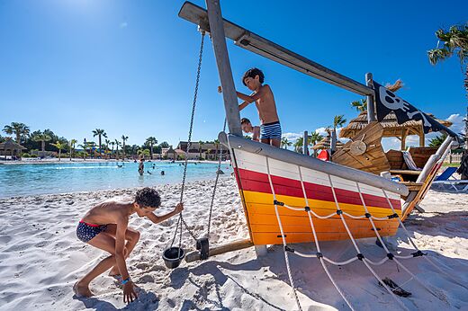 Zona de juegos barco pirata y piscina laguna en el camping CAPFUN La Nautique en Narbonne.