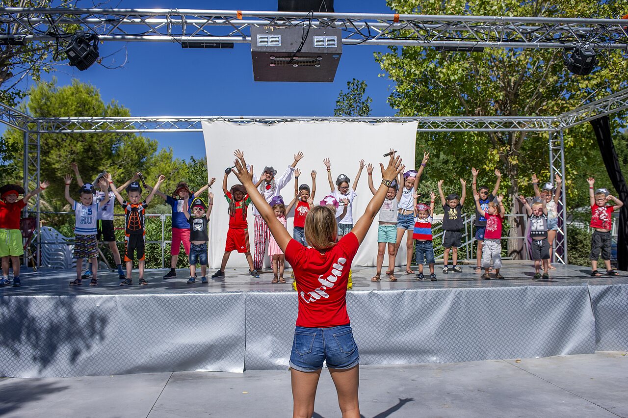 Ni�os participando en animaci�n en escenario exterior en camping CAPFUN La Nina en Agde (34).