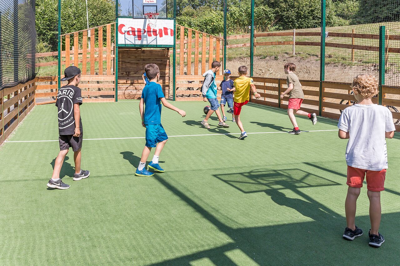Ni�os jugando f�tbol en campo multideportivo Capfun en el camping CAPFUN La Nina en Agde (34).