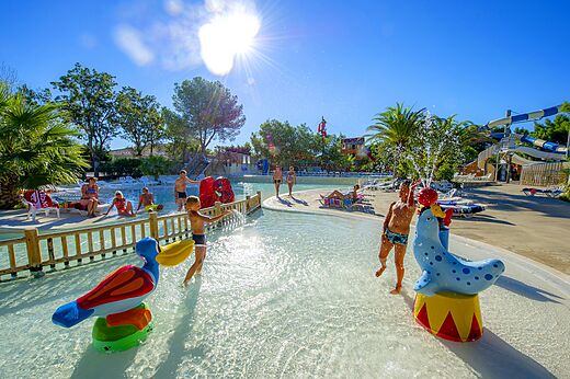 Zona de juegos acu�ticos con ni�os y animales rociadores en el camping CAPFUN La Nina en Agde (34).