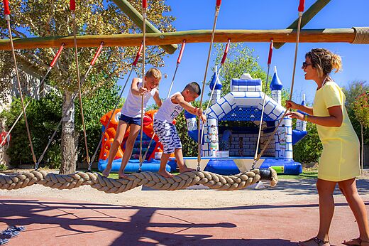 Niños en puente de cuerdas y juegos hinchables, camping CAPFUN La Nina Agde.