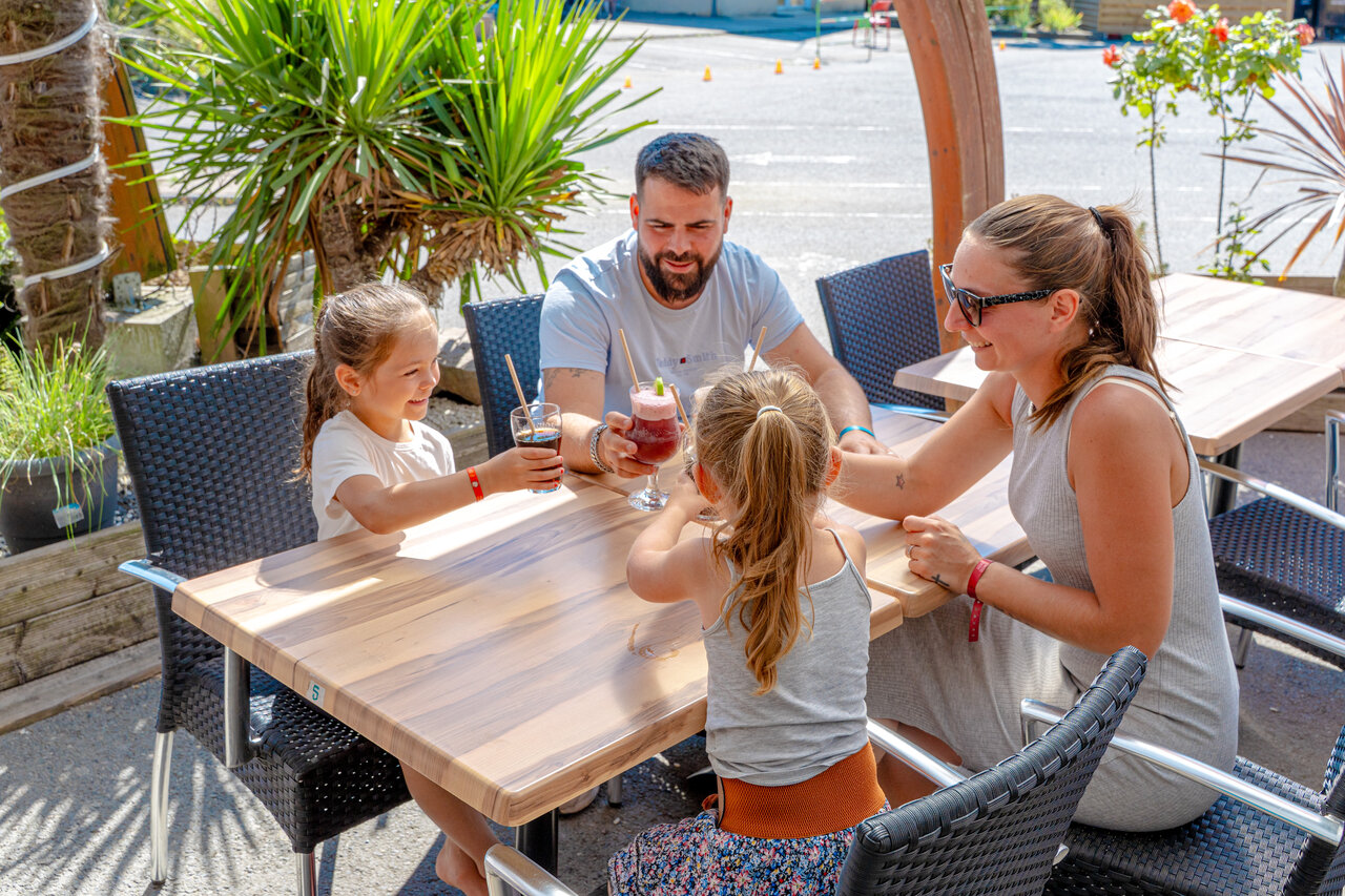 Familia disfrutando del bar exterior en el camping VAGUES OCEANES Odyss�e en Villers sur mer (14).
