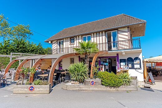 Restaurante y terraza exterior cubierta con mesas en el camping VAGUES OCEANES Odyssée en Villers sur mer (14).