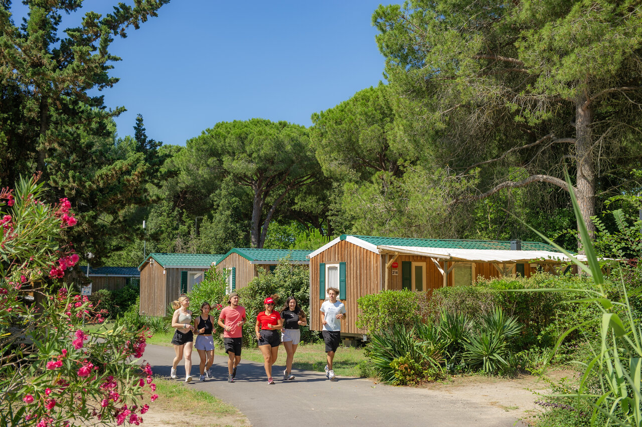 J�venes corriendo y mobile homes de madera en el camping CAPFUN Or, La Grande Motte (34).