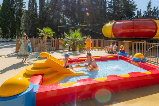 Piscina infantil colorida con tobog�n y juegos de agua en el camping CAPFUN Or en La Grande Motte (34).