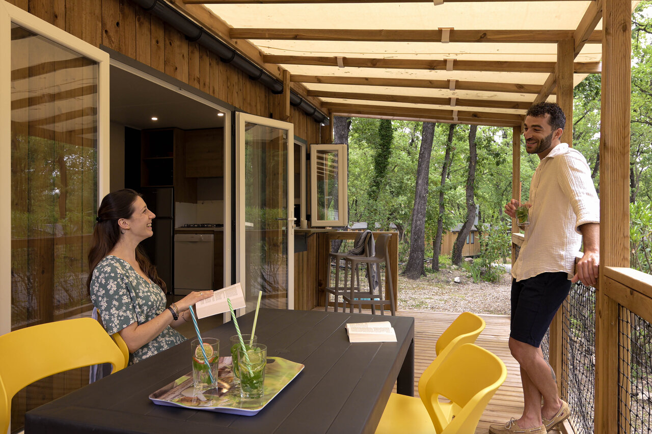 Pareja en terraza Mobil-home cubierta en camping CLICOCHIC Or�e d'Azur en OPIO (06).