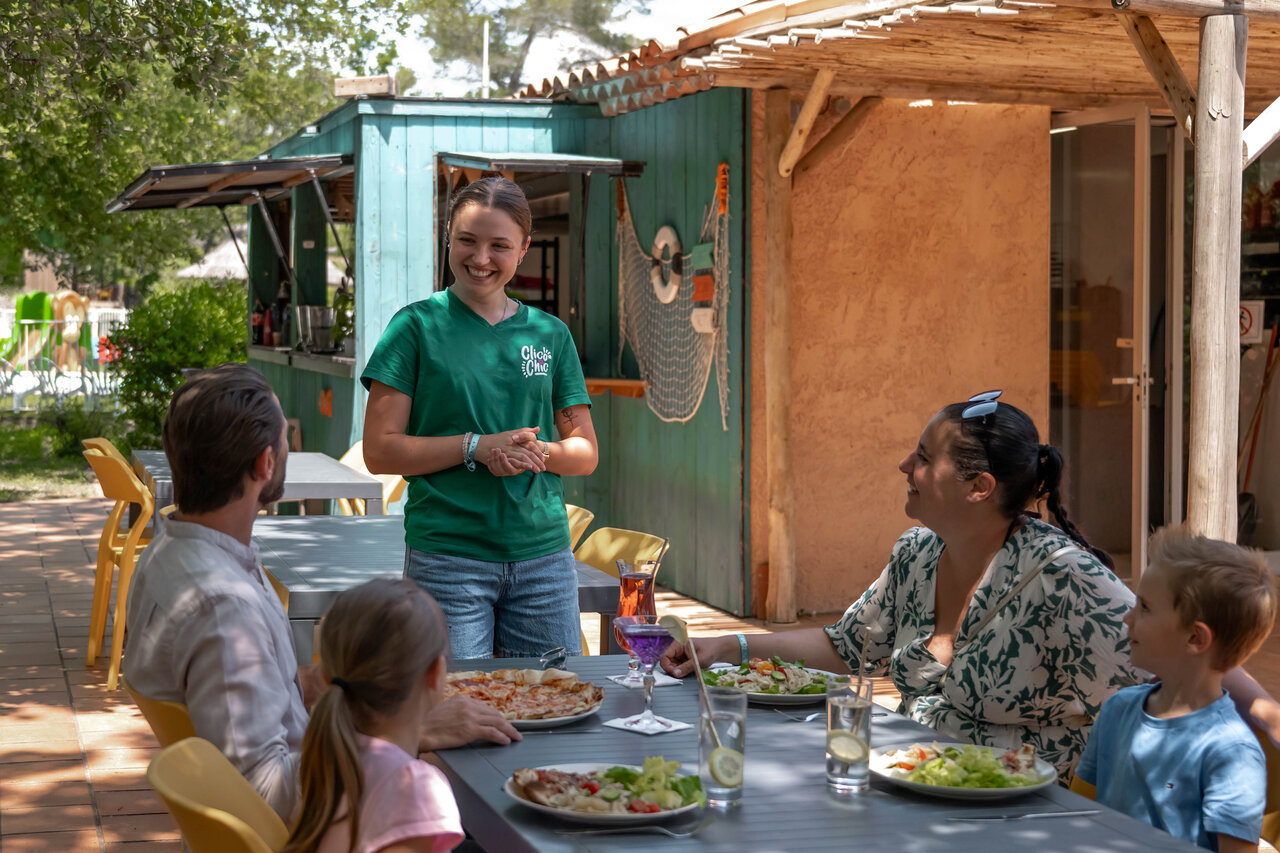Familia comiendo en terraza restaurante, empleada en camping CLICOCHIC Or�e d'Azur en OPIO (06).