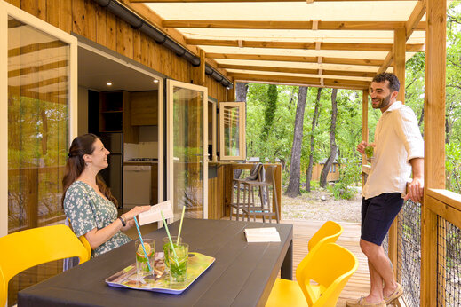 Pareja en la terraza de un Mobil-home moderno en el camping CLICOCHIC Or�e d'Azur en OPIO (06).