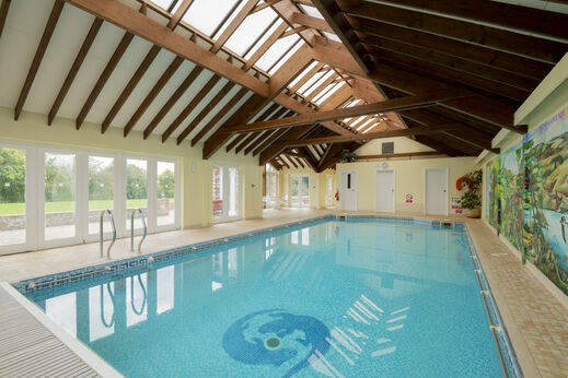 Piscina cubierta luminosa con techo de madera en el camping CAPFUN UK Otter Falls en Upottery Nr Honiton