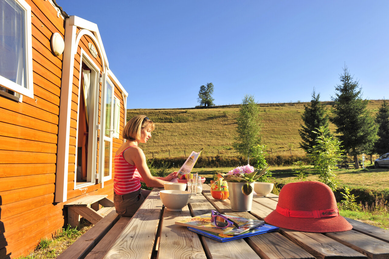 Mujer en terraza de Mobil-home, vista natural, en el camping CAPFUN Oursi�re en Villard de Lans (38).