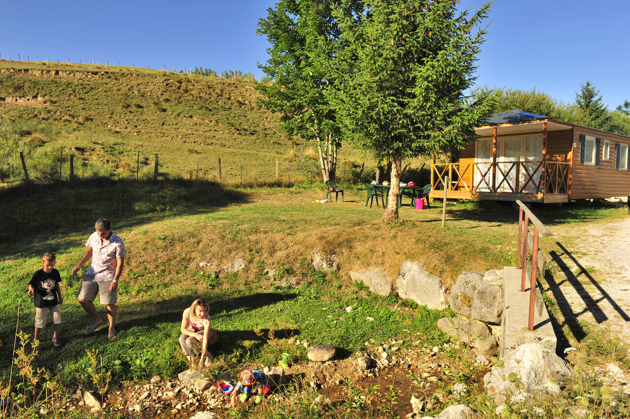 Mobil-home, familia y arroyo en CAPFUN Oursi�re en Villard de Lans (38).