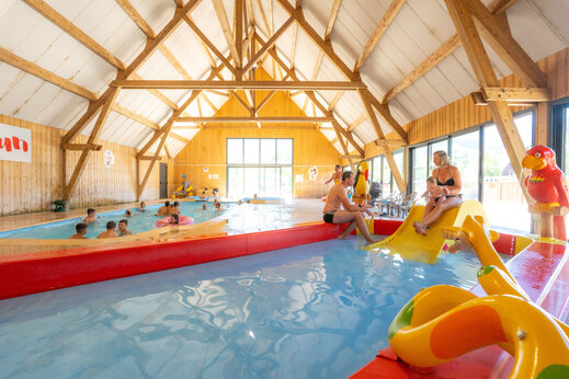 Piscina interior, tobogán y juegos infantiles en el camping CAPFUN Oursière en Villard de Lans.