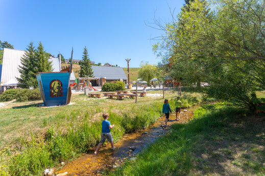 Niños jugando en el arroyo en el camping CAPFUN Oursière en Villard de Lans.