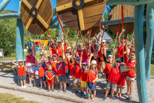 Niños sonrientes jugando en estructura de madera en camping CAPFUN Oursière en Villard de Lans (38).