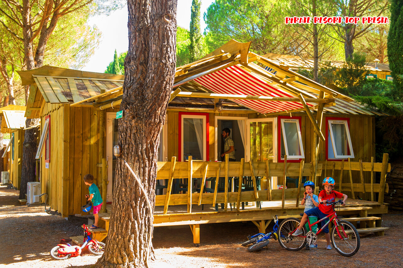 Mobil-home de madera, ni�os en bicicleta al camping CAPFUN Pachacaid en La Mole (83).