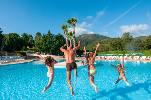 Piscina exterior, familia saltando alegremente en el camping CAPFUN Pachacaid en La Mole (83).