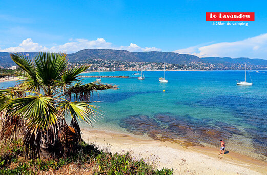 Playa de arena fina, mar turquesa y veleros en Le Lavandou, Var.