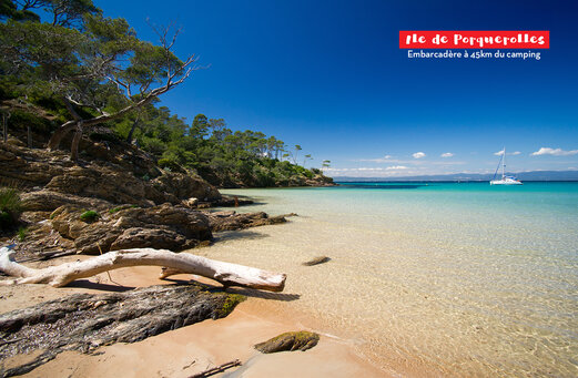Playa paradis�aca de la Isla de Porquerolles, aguas turquesas, costa rocosa y velero.