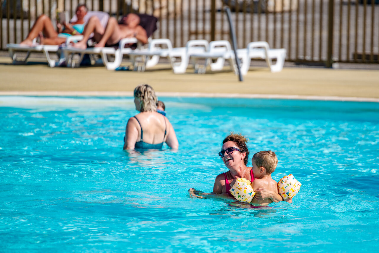 Mujer y ni�o sonriendo en la piscina exterior del camping CAPFUN Pachy en FOSSES LA VILLE.